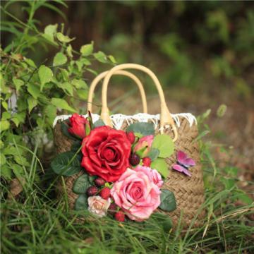 Women&#039;s handmade summer beach straw bag with rose flowers berries blossoms