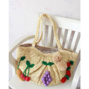 Women&#039;s handmade large summer beach straw bag with crocheted fruits and pom pom