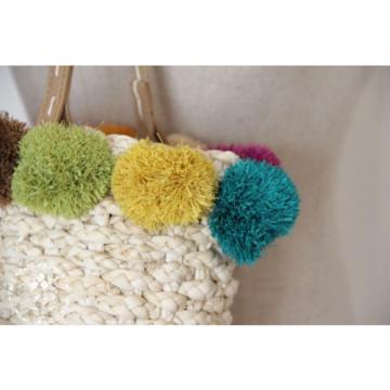 Women&#039;s handmade summer beach woven straw bag with colorful pom poms