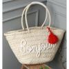 Women&#039;s handmade summer beach straw bag with letters graphic and tassel charm