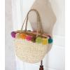 Women&#039;s handmade summer beach woven straw bag with colorful pom poms