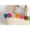 Women&#039;s handmade summer beach woven straw bag with colorful pom poms