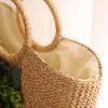 Women&#039;s handmade summer beach straw round bag with artificial flowers blossoms